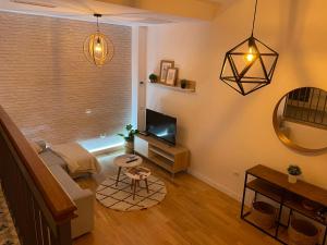 a living room with a couch and a television at Precioso Apartamento recién reformado en centro in Aranjuez