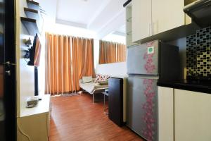 a kitchen with a refrigerator and a living room at Apartment Paragon Village by Tere Room in Tangerang