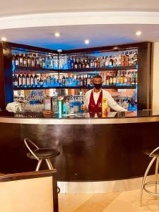 a bartender standing behind a bar in a restaurant at Indigo Hotel in Lagos