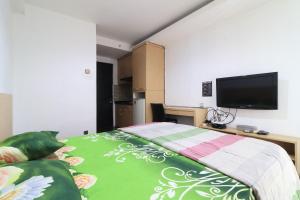 een slaapkamer met een bed en een flatscreen-tv bij Apartment Paragon Village by Tere Room in Tangerang