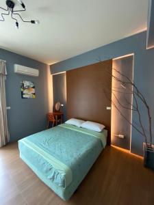台東市的住宿－魔法奶油飛民宿，一间卧室配有一张带蓝色墙壁的大床