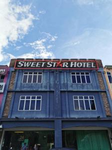 ein blaues Gebäude mit einem Schild, das süßes Himmelhotel liest in der Unterkunft Sweet Star Hotel in Alor Setar