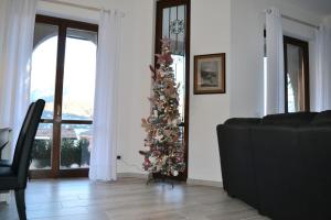 una sala de estar con un árbol de Navidad y un sofá en Le Grigne Guesthouse - The Garden, en Oliveto Lario