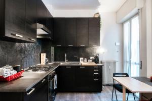 una cucina con armadi marroni scuri e tavolo di Apartment a Step from Lake Como a Como