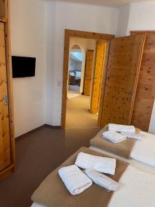 - une chambre avec 2 lits et des serviettes dans l'établissement W8 Haus Ganghofer, à Leutasch