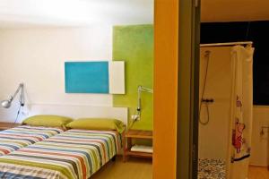 1 dormitorio con 2 camas de color verde y amarillo en Hotel rural HD Riudebitlles art i allotjament, en Sant Pere de Riudebitlles