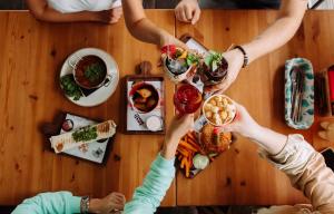 een groep mensen die rond een tafel eten bij BoogelWoogel Bar&Hotel Rosa Khutor in Esto-Sadok