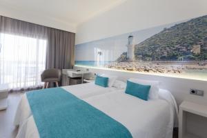 a hotel room with a bed and a view of a beach at Hotel Obelisco in Playa de Palma