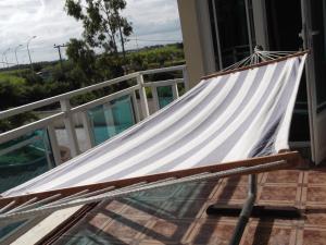 a hammock on the balcony of a house at Luxor Residence Guesthouse in Belle Mare