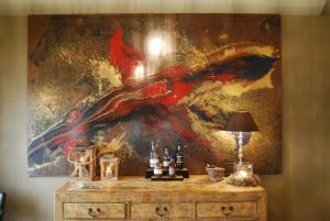 una pintura en una pared sobre un tocador con botellas. en B&B Het Merelnest, en Waardamme