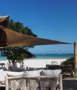 Eleven Pearl Boutique Hotel & Spa في شاطئ دياني: طاولة مع مظلة على الشاطئ