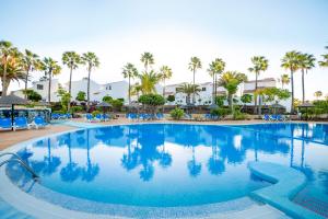 una grande piscina in un resort con palme di Wyndham Residences Golf del Sur a San Miguel de Abona