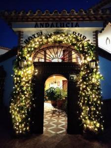 Un arco con luces de Navidad delante de un edificio en Hotel Rural Andalucia, en Sierra de Yeguas