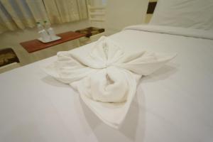 Hotel Palmyra Grand Inn في تيرونلفلي: منشفه بيضاء تجلس فوق سرير ابيض