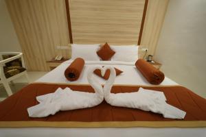 two swans made out of towels on a bed at Hotel Palmyra Grand Inn in Tirunelveli