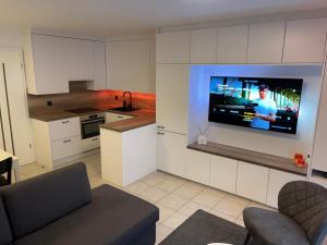 eine Küche mit einem TV an der Wand in einem Zimmer in der Unterkunft Luxe appartement I 2 slaapkamers I 2 x dubbel bed I 75m van het strand I Nieuwpoort-Bad in Nieuwpoort