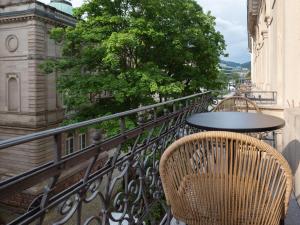 a balcony with two chairs and a table at Limehome Baden-Baden Bäderstraße in Baden-Baden +42 photos