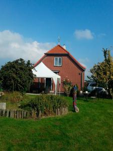a red brick house with a white tent in the yard at Ferienhaus Schwille - Loft 2 in Westerbergen