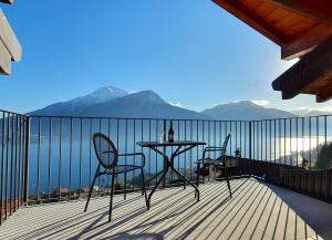 un tavolo e sedie su un balcone con vista sulle montagne di Appartamento Roberta a Musso