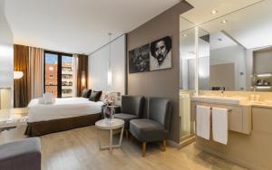 une chambre d'hôtel avec un lit et une salle de bain dans l'établissement Grums Hotel & Spa, à Barcelone