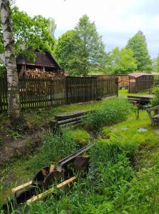 a yard with a wooden fence and a wooden table at Chata pod lesem in Rýmařov