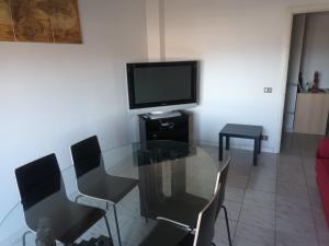 un soggiorno con tavolo in vetro e TV di Appartamento Belvedere a Chieti