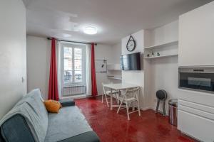 ein Wohnzimmer mit Sofa und Tisch in der Unterkunft Logement entier à Paris in Paris