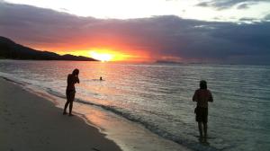 two people standing on the beach watching the sunset at Jasmine & Tea House in Mae Nam