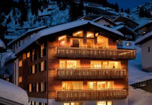ein Gebäude mit eingeschalteten Lichtern im Schnee in der Unterkunft Haus Burgi - Angelika Walch in Stuben am Arlberg