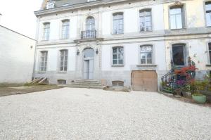 un grand bâtiment blanc avec une grande allée. dans l'établissement La Maison de la Duchesse de la Vallière - Parking privé gratuit, à Mons
