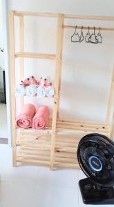 estante de madera con toallas rosas y ventilador en HOSTEL CASA DA VÓ ROSA en Governador Celso Ramos