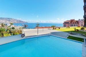 a large swimming pool with a view of the ocean at Quinta Miramar in Funchal