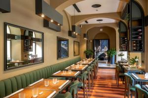 un restaurante con mesas de madera y asientos verdes en Hotel San Francesco, en Roma