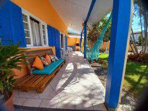 a porch of a house with a bench and a hammock at Casa Praia da Pinheira a 50m praia in Pinheira