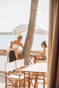 two women sitting at a table on the beach at Nomad Hotel - Xábia Port in Jávea