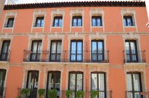 un edificio naranja con ventanas y balcones en Casa Palacio de los Sitios, en Zaragoza