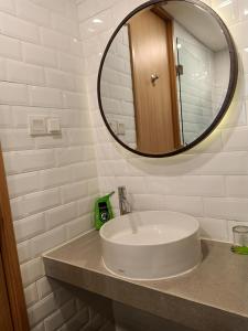 a white bathroom with a sink and a mirror at MaxOneHotels Loji Kridanggo @Boyolali in Boyolali