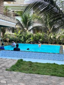 un groupe de personnes dans une piscine dans l'établissement Neville's Villa - Pet friendly with Pool, à Alibaug
