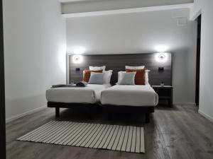 1 dormitorio con 1 cama blanca grande y 1 alfombra en PincoPancoRooms, en Acquasanta Terme