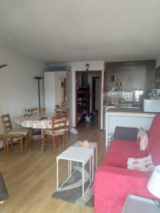 ein Wohnzimmer mit einem roten Sofa und einem Tisch in der Unterkunft Residence Pierre Aigue in Saint-Sorlin-dʼArves