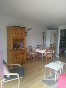 sala de estar con mesa y sillas y cocina en Residence Pierre Aigue en Saint-Sorlin-dʼArves