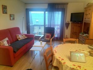 a living room with a couch and a table with a laptop at Résidence Pierre Aiguë in Saint-Sorlin-dʼArves