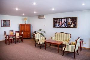 una sala de espera con sillas y una mesa y una foto en la pared en DIS Hotel, en Cheboksary