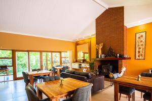 a living room with tables and chairs and a fireplace at bWhale guest house in Knysna