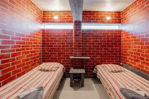 a room with two beds and a brick wall at Hotelli Selli in Vihti