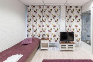 - une chambre avec un lit, une télévision et des rideaux dans l'établissement Hotelli Selli, à Vihti