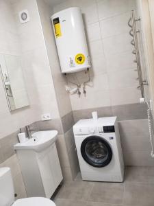 a bathroom with a washing machine and a sink at Apart Ugorska in Lviv