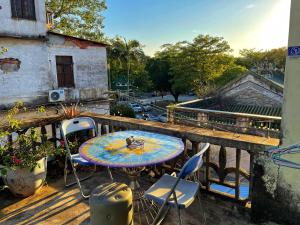 a patio with a table and chairs on a balcony at Yellow House Hostel Huizhou West Lake in Huizhou