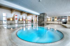 duży niebieski basen w holu w obiekcie Appartement & Suiten Hotel Glöcknerin w mieście Obertauern