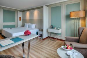 ein Hotelzimmer mit einem Bett und einem Tisch in der Unterkunft Windsor Plaza Hotel in Ho-Chi-Minh-Stadt
